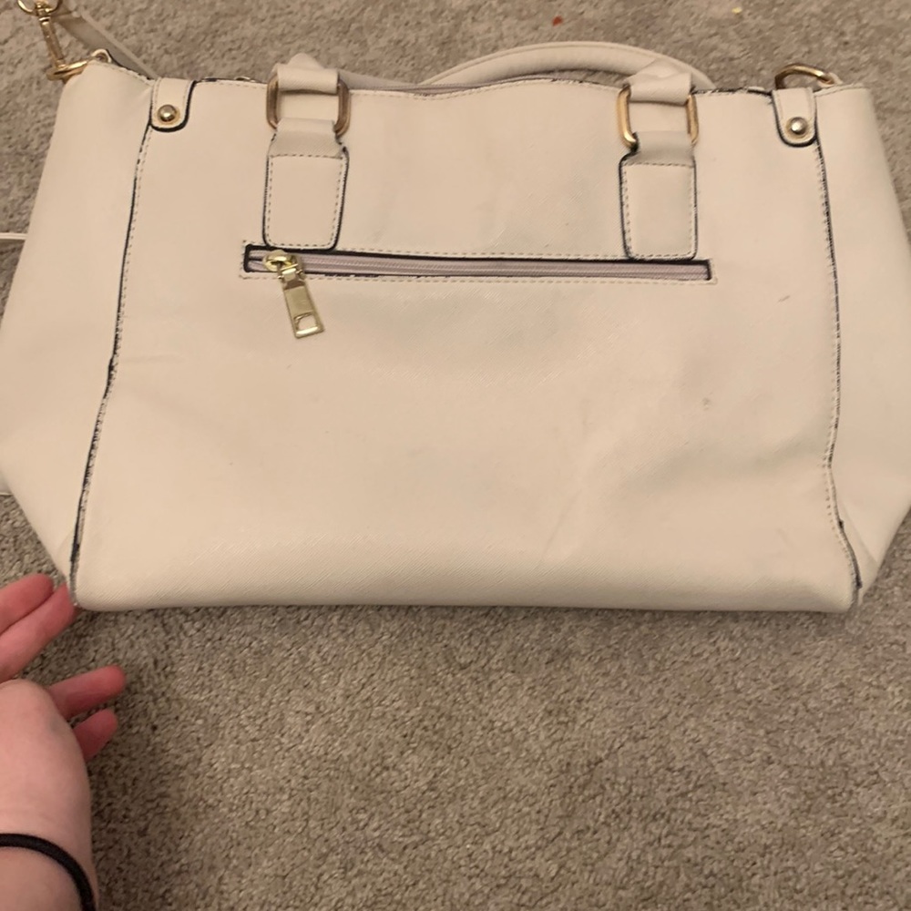 Big off white purse with gold zippers and white and blue inside(extra long strap